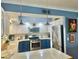 Bright kitchen boasts white and blue cabinetry, stainless steel appliances, and ample counter space at 1345 S Evergreen Ave, Clearwater, FL 33756