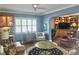 Inviting living room with built-in bar, wood floors, ceiling fan, and light-filled windows at 1345 S Evergreen Ave, Clearwater, FL 33756
