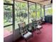 Relaxing screened porch with outdoor seating, a grill, and lush greenery surrounding at 1345 S Evergreen Ave, Clearwater, FL 33756