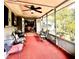 Relaxing screened porch with comfortable seating and a ceiling fan at 1345 S Evergreen Ave, Clearwater, FL 33756
