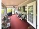 Inviting screened porch with outdoor seating, a fan, and access to a lush backyard at 1345 S Evergreen Ave, Clearwater, FL 33756