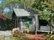Charming shed with whimsical mural, swing, and brick patio surrounded by vibrant plants and flowers at 1345 S Evergreen Ave, Clearwater, FL 33756