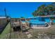 Poolside view of home with above ground pool and wooden deck at 13970 Montego Dr, Seminole, FL 33776