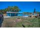 Inviting backyard featuring an above-ground pool, fire pit, patio and wooden shed at 13970 Montego Dr, Seminole, FL 33776