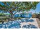 Single-story home featuring a well-maintained lawn, driveway, and beautiful shade tree at 13970 Montego Dr, Seminole, FL 33776