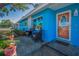 Inviting front porch with stylish seating area and bright blue exterior paint at 13970 Montego Dr, Seminole, FL 33776