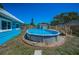 Backyard showing the above ground pool surrounded by decorative stone at 13970 Montego Dr, Seminole, FL 33776