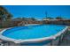 Backyard showing pool with white ladder entry and wooden deck on a sunny day at 13970 Montego Dr, Seminole, FL 33776