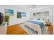 Bright bedroom featuring hardwood floors, a ceiling fan, and blue accents that complement the decor and area rug at 1431 Kings Hwy, Clearwater, FL 33755