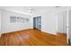 Bright bedroom featuring hardwood floors, a ceiling fan, and closet space with shelving to meet storage needs at 1431 Kings Hwy, Clearwater, FL 33755