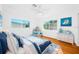 Bright bedroom features hardwood floors, dual windows for ample natural light, and blue accents, creating a peaceful retreat at 1431 Kings Hwy, Clearwater, FL 33755