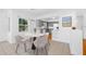 Modern dining area features tile floors, contemporary chairs, and views into the updated gray kitchen at 1431 Kings Hwy, Clearwater, FL 33755