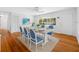Dining room with modern rug, white table setting, bright window, and hardwood floors at 1431 Kings Hwy, Clearwater, FL 33755