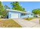 Inviting single-story home with an attached garage and a charming white picket fence at 1431 Kings Hwy, Clearwater, FL 33755
