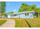 Attractive house with a blue exterior, white trim, and a neatly manicured lawn at 1431 Kings Hwy, Clearwater, FL 33755