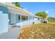 Inviting front porch with white picket fence, blue exterior, and well-manicured lawn, perfect for relaxing at 1431 Kings Hwy, Clearwater, FL 33755