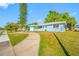 Charming blue house with a well-manicured front yard and inviting walkway at 1431 Kings Hwy, Clearwater, FL 33755