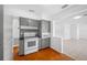 Classic kitchen with gray cabinets, white appliances, and tile flooring adjacent to living space at 1431 Kings Hwy, Clearwater, FL 33755