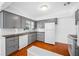 Functional kitchen with gray cabinetry, a double sink, and tile flooring at 1431 Kings Hwy, Clearwater, FL 33755