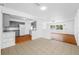Open-concept home featuring a gray kitchen, wood flooring, tile flooring, and lots of natural light at 1431 Kings Hwy, Clearwater, FL 33755
