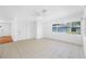 Bright living room with tile flooring, ceiling fan, and natural light from large windows at 1431 Kings Hwy, Clearwater, FL 33755