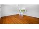 Spacious living room with hardwood floors, white painted brick wall, and views into other rooms at 1431 Kings Hwy, Clearwater, FL 33755