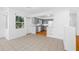 View of living room adjacent to the gray kitchen, with tile flooring, wood flooring, and lots of natural light at 1431 Kings Hwy, Clearwater, FL 33755