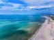 Wide aerial view of turquoise ocean waters meeting a long, sandy beach under a blue sky at 1451 Gulf Blvd # 207, Clearwater Beach, FL 33767