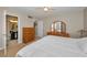 Bright bedroom featuring a ceiling fan, wood dresser and vanity, and an attached bathroom at 1451 Gulf Blvd # 207, Clearwater Beach, FL 33767