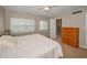 Bedroom with a king bed, windows with white shutters, wood dresser, and ensuite bathroom at 1451 Gulf Blvd # 207, Clearwater Beach, FL 33767