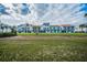 Low-angle view of the condos with balconies and lush lawn under a partly cloudy sky at 1451 Gulf Blvd # 207, Clearwater Beach, FL 33767