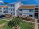 Inviting exterior view of a two-story condo featuring well-kept landscaping and a carport at 1451 Gulf Blvd # 207, Clearwater Beach, FL 33767