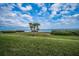Lush green lawn adorned with palm trees and hedges overlooking tranquil bay waters at 1451 Gulf Blvd # 207, Clearwater Beach, FL 33767