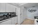 Well-lit kitchen with white cabinets, granite counters, stainless microwave, and a double door refrigerator at 1451 Gulf Blvd # 207, Clearwater Beach, FL 33767
