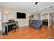 Open living room features a piano, hardwood floors, large windows, and modern decor, ideal for comfortable living at 1451 Gulf Blvd # 207, Clearwater Beach, FL 33767