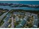 An aerial view displays community buildings surrounded by lush trees, a pool, and waterfront views on a clear sunny day at 14692 Seminole Trl, Seminole, FL 33776