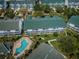 An aerial view features residences, a pool surrounded by palm trees, and manicured green spaces within the community at 14692 Seminole Trl, Seminole, FL 33776