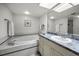 Bright bathroom featuring a tub, vanity, large mirror, vanity, tile floor, recessed lighting, and neutral paint at 14692 Seminole Trl, Seminole, FL 33776