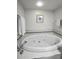 A well lit bathroom featuring a large tub with jets, tiled walls, chrome fixtures, and neutral paint at 14692 Seminole Trl, Seminole, FL 33776