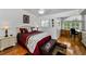 Well lit bedroom features ceiling fan, hardwood floors, en suite office, bench and neutral paint at 14692 Seminole Trl, Seminole, FL 33776