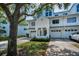 Charming townhome exterior featuring white siding, attached garage, and mature landscaping at 14692 Seminole Trl, Seminole, FL 33776