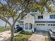 A well-maintained townhouse features an attached garage, verdant lawn, and mature trees at 14692 Seminole Trl, Seminole, FL 33776