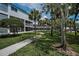 Well-maintained condo complex with lush landscaping, palm trees, and a sidewalk at 14692 Seminole Trl, Seminole, FL 33776