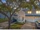Charming townhome exterior featuring white siding, attached garage, and verdant landscaping at 14692 Seminole Trl, Seminole, FL 33776