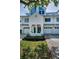 Charming townhome exterior featuring white siding, attached garage, and colorful landscaping at 14692 Seminole Trl, Seminole, FL 33776