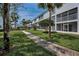 Walkway of white condo building with palm trees and grass at 14692 Seminole Trl, Seminole, FL 33776