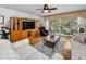 Bright living room featuring hardwood floors, ceiling fan, and sliding glass doors to the balcony at 14692 Seminole Trl, Seminole, FL 33776