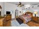 A spacious main bedroom showcasing a ceiling fan, hardwood floors, sitting area, rug, and bedroom furniture at 14692 Seminole Trl, Seminole, FL 33776