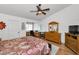 Bright main bedroom featuring a ceiling fan, wood floors, en suite office area and abundant natural light at 14692 Seminole Trl, Seminole, FL 33776