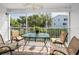 Cozy screened lanai with a glass-topped table and comfortable chairs, perfect for outdoor relaxation at 14692 Seminole Trl, Seminole, FL 33776